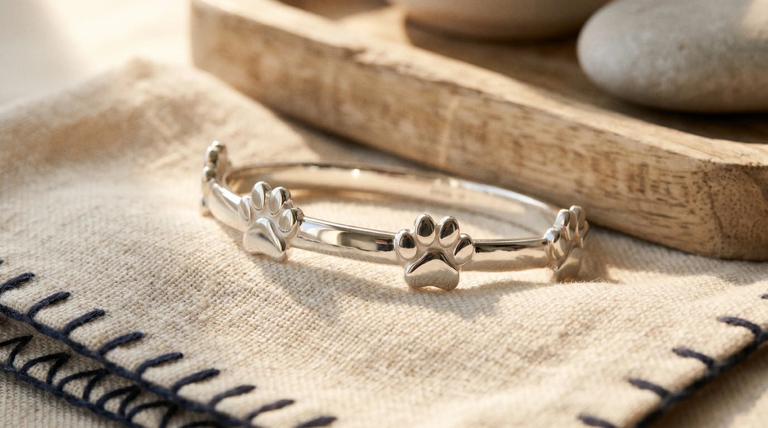 Close-up of a polished silver paw-print bracelet showing pristine untarnished surface