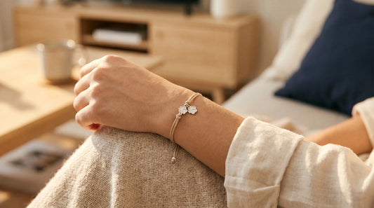 A delicate dog paw pendant layered with a fine name chain in warm afternoon light