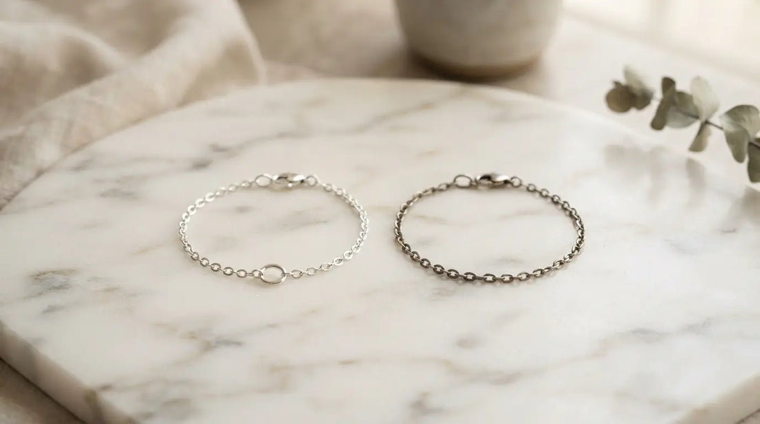 Two silver bracelets side by side on marble — 316L surgical grade vs 304 stainless steel comparison