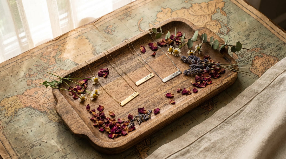 Personalized necklaces arranged on a vintage world map with dried flowers from different regions in overhead light