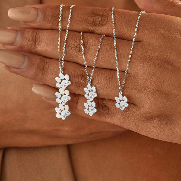 Close-up of engraved paw print pendant on dainty necklace — waterproof everyday jewelry
