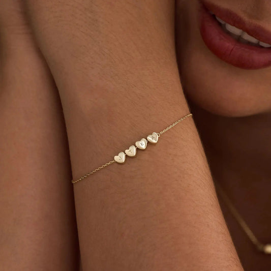 Heart initial bracelet styled on woman's wrist — romantic everyday personalized jewelry