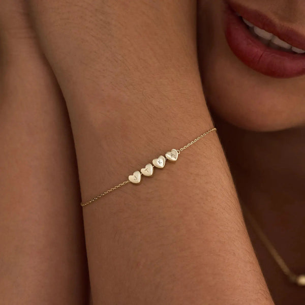 Heart initial bracelet styled on woman's wrist — romantic everyday personalized jewelry